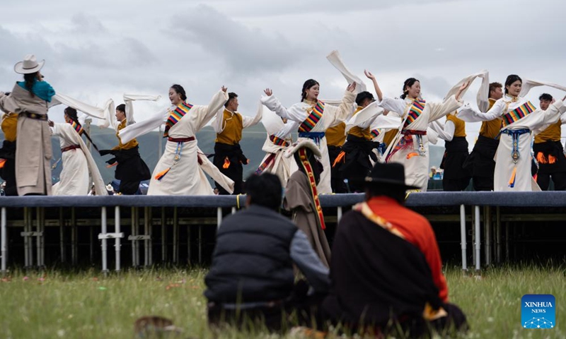 Locals perform Guozhuang dance on a grassland in Baiyu County, Garze Tibetan Autonomous Prefecture, southwest China's Sichuan Province, July 27, 2024. A rural folk event kicked off here on Saturday, consisting of performances, milking competition, yak beauty contest, horse racing and other activities. Photo: Xinhua