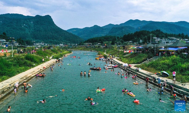 An aerial drone photo taken on July 27, 2024 shows people cooling off in a river at Lianhua Village, Longshan Town, Longli County, southwest China's Guizhou Province. During summer vacation, Longli County has become a popular destination for tourists to escape the sweltering summer heat. In recent years, local authorities have promoted the upgrading of the rural tourism, which attracts more tourists to visit. Photo: Xinhua