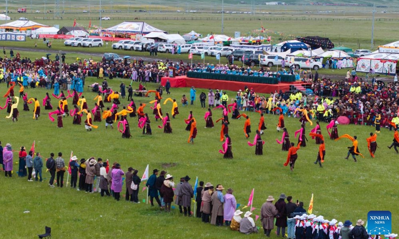 Locals perform Guozhuang dance on a grassland in Baiyu County, Garze Tibetan Autonomous Prefecture, southwest China's Sichuan Province, July 27, 2024. A rural folk event kicked off here on Saturday, consisting of performances, milking competition, yak beauty contest, horse racing and other activities. Photo: Xinhua