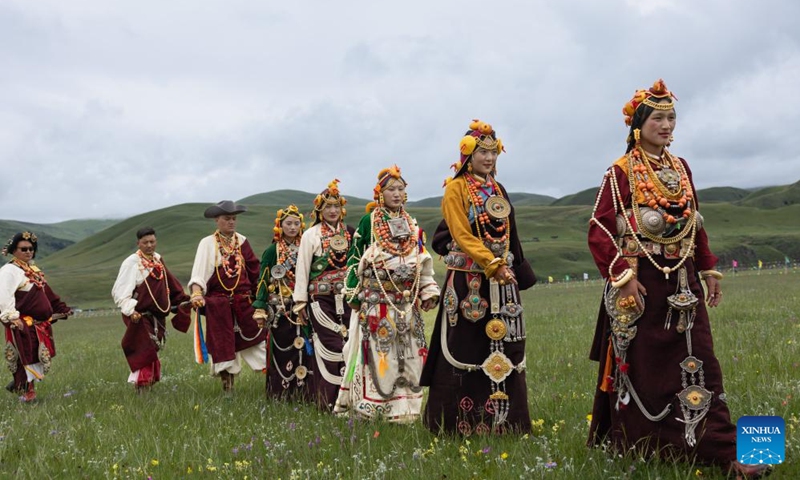 Local people display traditional costumes on a grassland in Baiyu County, Garze Tibetan Autonomous Prefecture, southwest China's Sichuan Province, July 27, 2024. A rural folk event kicked off here on Saturday, consisting of performances, milking competition, yak beauty contest, horse racing and other activities. Photo: Xinhua