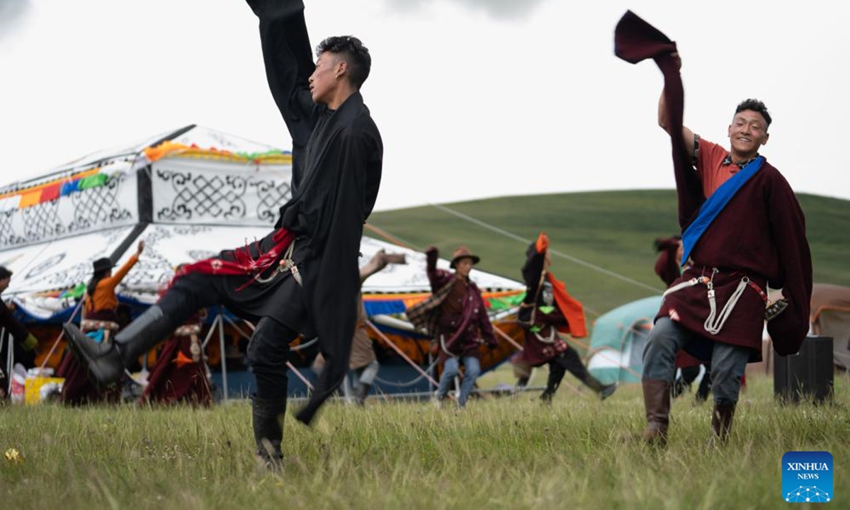 Local people perform Guozhuang dance on a grassland in Baiyu County, Garze Tibetan Autonomous Prefecture, southwest China's Sichuan Province, July 27, 2024. A rural folk event consisting of performances, horse racing, yak beauty contest, and other activities have attracted many participants. (Photo: Xinhua)