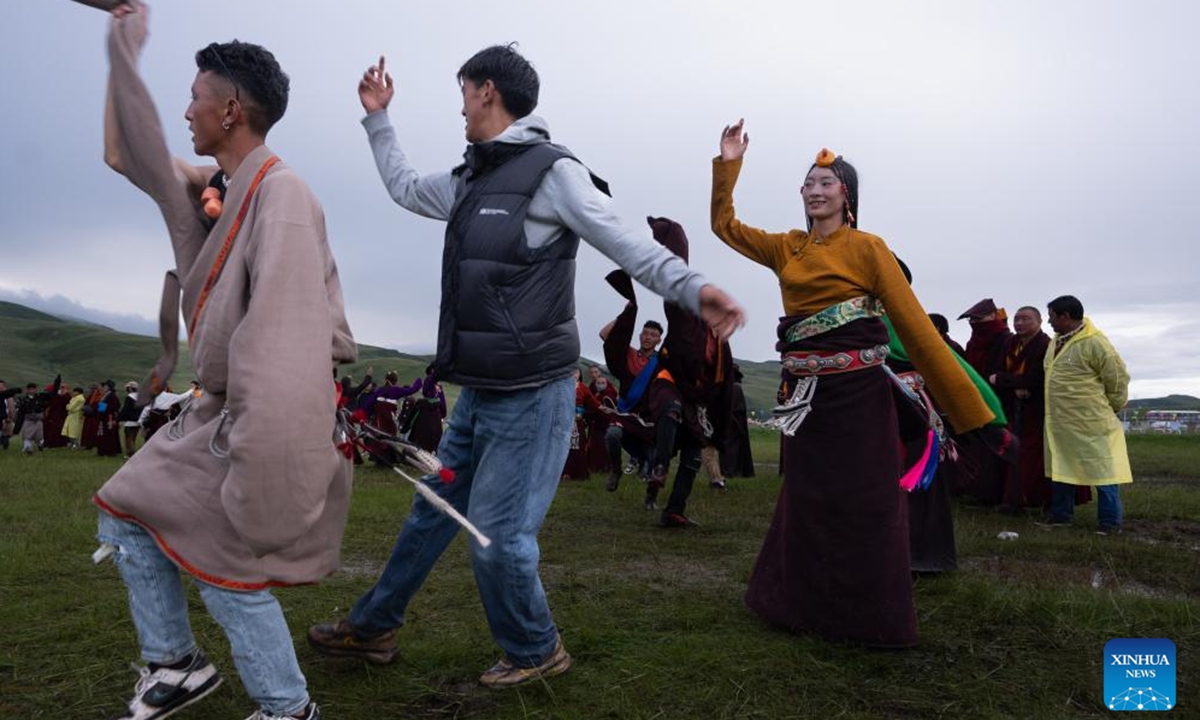 Local people perform Guozhuang dance on a grassland in Baiyu County, Garze Tibetan Autonomous Prefecture, southwest China's Sichuan Province, July 27, 2024. A rural folk event consisting of performances, horse racing, yak beauty contest, and other activities have attracted many participants. (Photo: Xinhua)