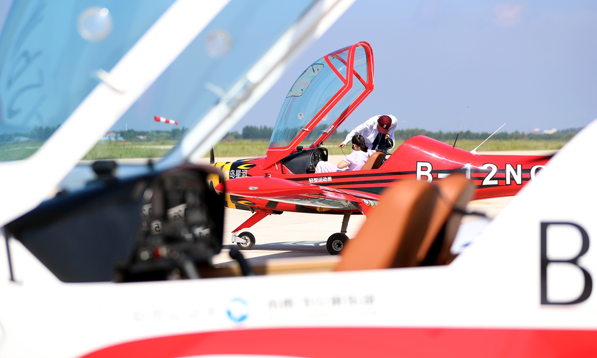 A flight enthusiast experiences flying a light sports aircraft in Qingdao, East China's Shandong Province, on July 30, 2024. In recent years, Qingdao has seized new economic opportunities in low-altitude airspace, taking advantage of its favorable airspace conditions. China is eyeing buzzing low-altitude skies as a new growth engine. The size of China's low-altitude economy is expected to rise to 2 trillion yuan ($276 billion) by 2030. Photo: VCG