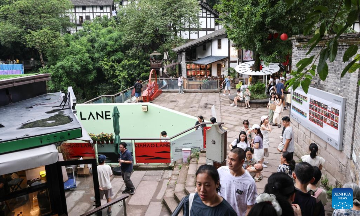 Tourists visit Longmenhao old street in Nan'an District in southwest China's Chongqing Municipality, July 28, 2024. Longmenhao old street, featuring more than 200 ancient architectures built in different forms and periods, was listed in the first batch of urban renewal pilot projects launched by Chongqing. In recent years, local authorities have been integrating natural, cultural, artistic, digital and other elements into the renovation of the street, and readjusting the layout according to its historical and cultural characteristics. (Photo: Xinhua)