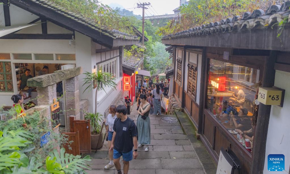 Tourists visit Longmenhao old street in Nan'an District in southwest China's Chongqing Municipality, July 28, 2024. Longmenhao old street, featuring more than 200 ancient architectures built in different forms and periods, was listed in the first batch of urban renewal pilot projects launched by Chongqing. In recent years, local authorities have been integrating natural, cultural, artistic, digital and other elements into the renovation of the street, and readjusting the layout according to its historical and cultural characteristics. (Photo: Xinhua)