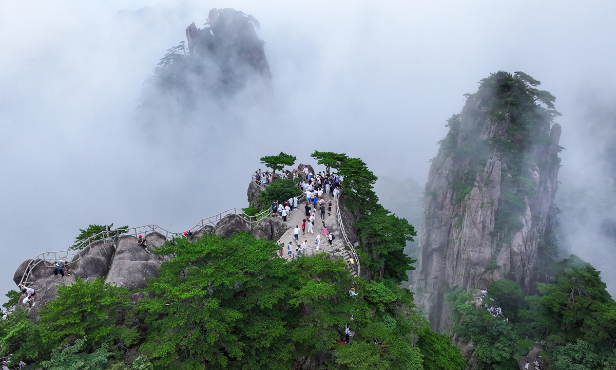 Tourists enjoy the scenery at the Huangshan Mountain scenic area in East China's Anhui Province, on July 30, 2024. Huangshan Mountain, also known as Yellow Mountain, is a UNESCO World Heritage Site covering an area of 1,200 square kilometers and is famous for its peculiar shaped rocks, cloud-shrouded peaks, pine trees and hot springs. Photo: VCG