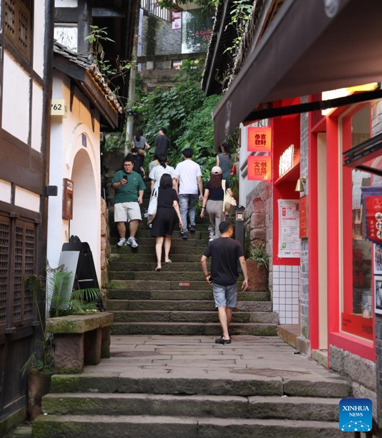 Tourists visit Longmenhao old street in Nan'an District in southwest China's Chongqing Municipality, July 28, 2024. Longmenhao old street, featuring more than 200 ancient architectures built in different forms and periods, was listed in the first batch of urban renewal pilot projects launched by Chongqing. In recent years, local authorities have been integrating natural, cultural, artistic, digital and other elements into the renovation of the street, and readjusting the layout according to its historical and cultural characteristics. (Photo: Xinhua)