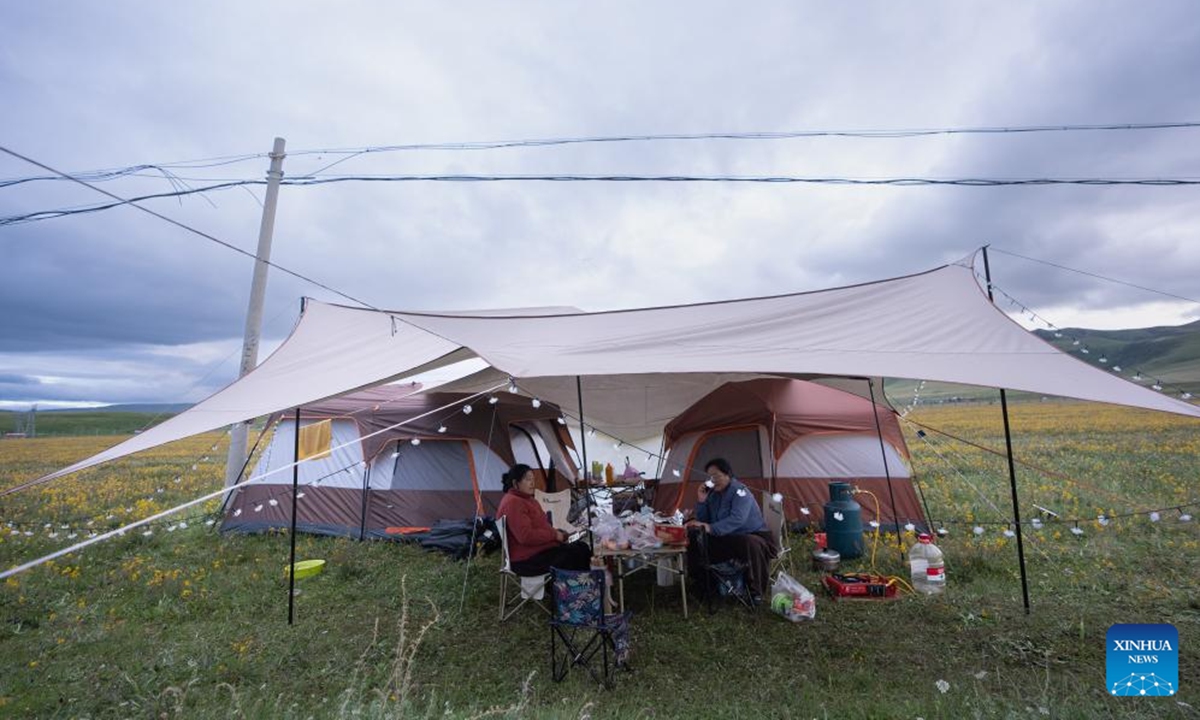 Local people set up tents and tarps for camping on a grassland in Baiyu County, Garze Tibetan Autonomous Prefecture, southwest China's Sichuan Province, July 28, 2024. A rural folk event consisting of performances, horse racing, yak beauty contest and other activities have attracted many participants. (Photo: Xinhua)