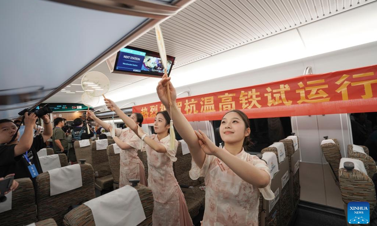 Staff members stage a show on the first trial bullet train G55701 on the new high-speed railway linking Hangzhou and Wenzhou in east China's Zhejiang Province, July 30, 2024. A new high-speed railway went into trial operation on Tuesday linking two economic heavyweights of Hangzhou and Wenzhou cities in east China's Yangtze River Delta region. (Photo: Xinhua)