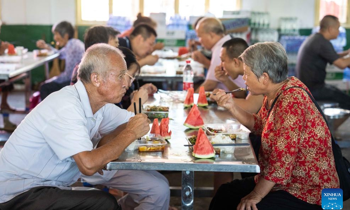 Relocated residents have lunch at a  in a school in Xiangtan County, central China's Hunan Province, July 30, 2024. Heavy rainstorms in the aftermath of Typhoon Gaemi have wreaked havoc across Hunan. In Xiangtan County, three dike breaches occurred in the Juanshui River in the past few days, prompting the evacuation of thousands of residents. (Photo: Xinhua)