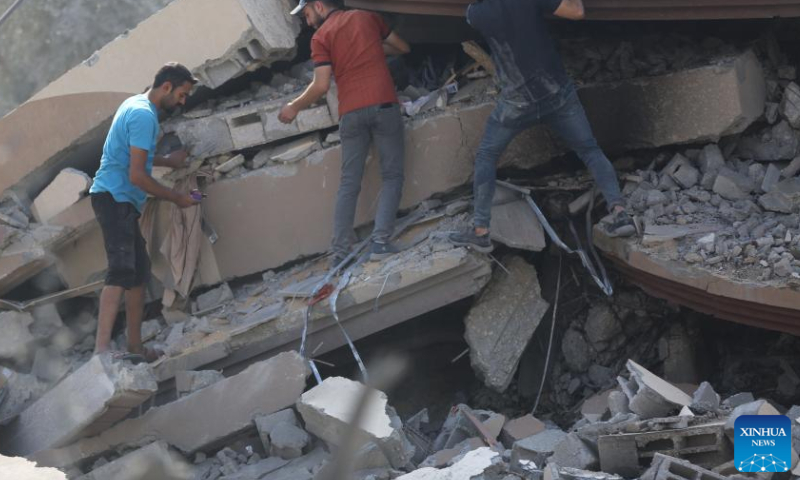 People search among the rubble after an Israeli airstrike in the Nuseirat refugee camp, central Gaza Strip, on Aug. 12, 2024. The Palestinian death toll from ongoing Israeli attacks on the Gaza Strip has risen to 39,897, Gaza-based health authorities said in a statement on Monday. (Photo by Marwan Dawood/Xinhua)