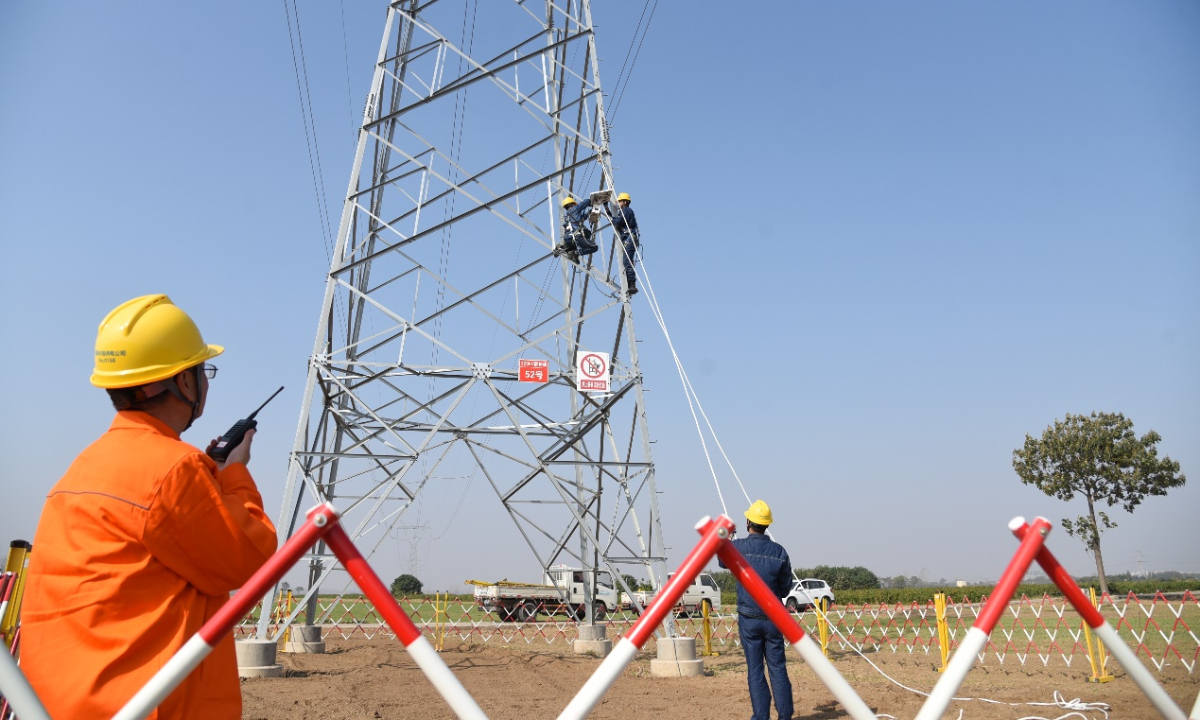 Staff install transmission line online monitoring device.