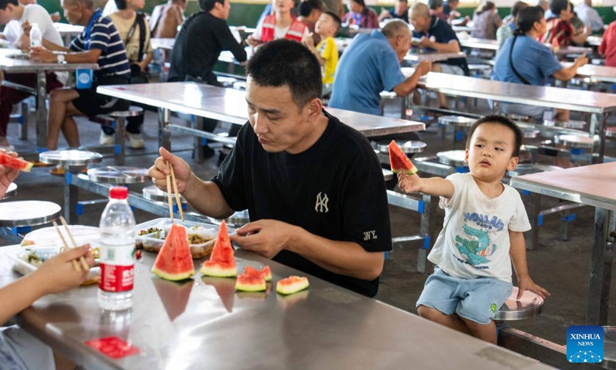 Relocated residents have lunch at a relocation site in a school in Xiangtan County, central China's Hunan Province, July 30, 2024. Heavy rainstorms in the aftermath of Typhoon Gaemi have wreaked havoc across Hunan. In Xiangtan County, three dike breaches occurred in the Juanshui River in the past few days, prompting the evacuation of thousands of residents. (Photo: Xinhua)