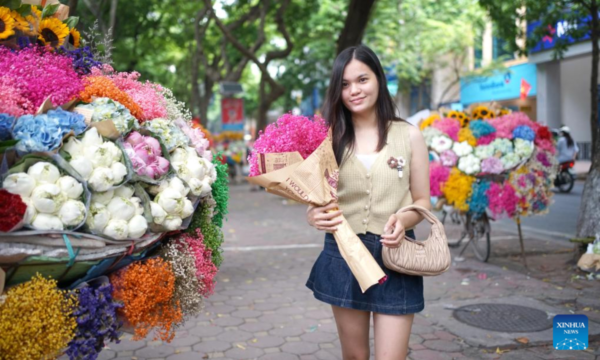 A woman buys flowers at a flower stall in Hanoi, Vietnam, Aug. 16, 2024. (Photo: Xinhua)