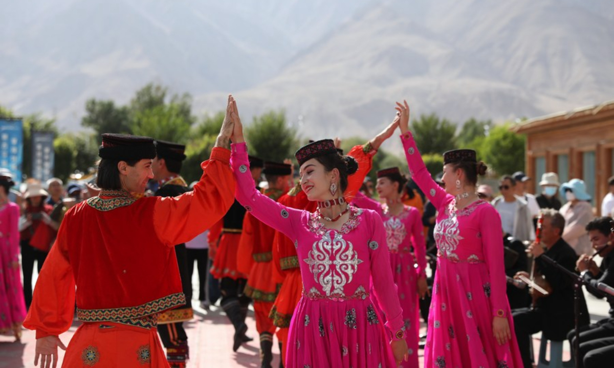 Gulbanur Kurqak dances with her colleagues to welcome tourists in front of the customer service center of Pamir Tourist Area in Taxkorgan Tajik Autonomous County,<strong></strong> northwest China's Xinjiang Uygur Autonomous Region, Sep 4, 2023. Photo:Xinhua