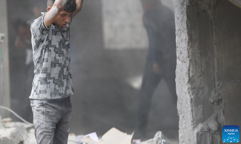 People are seen in a house damaged in an Israeli airstrike in the Nuseirat refugee camp, central Gaza Strip, on Aug. 12, 2024. The Palestinian death toll from ongoing Israeli attacks on the Gaza Strip has risen to 39,897, Gaza-based health authorities said in a statement on Monday. (Photo by Marwan Dawood/Xinhua)