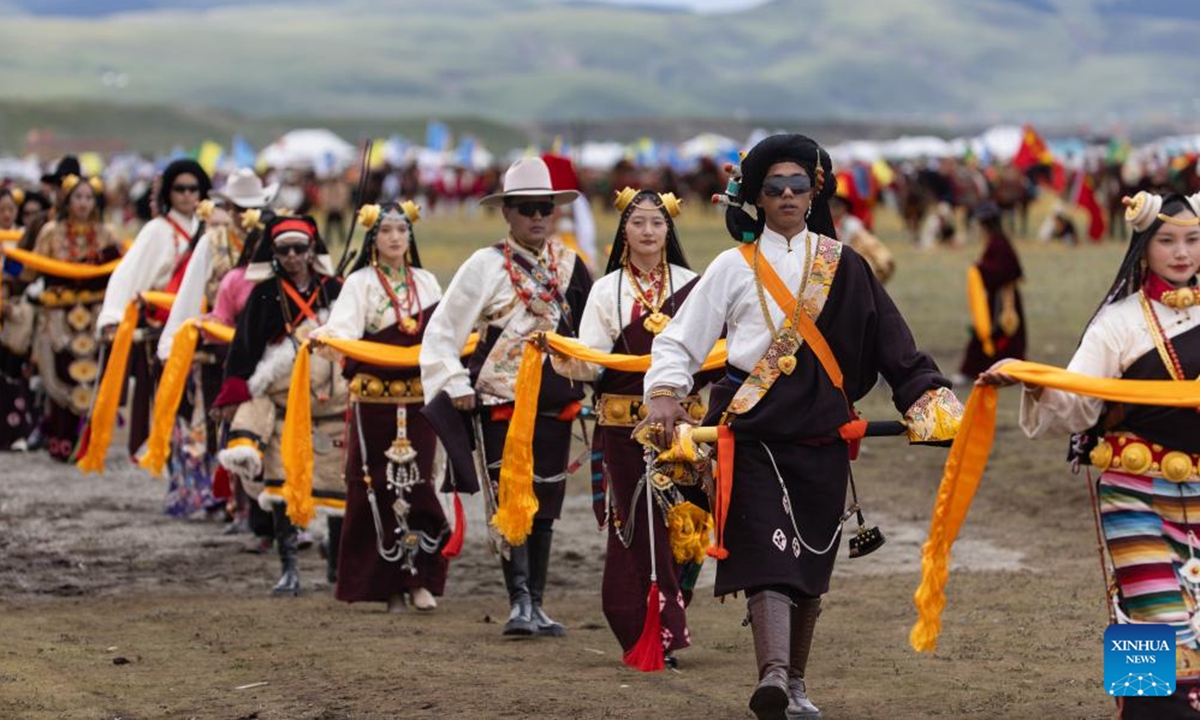 Locals demonstrate their traditional costumes at a racecourse in Litang County, the Tibetan Autonomous Prefecture of Garze, southwest China's Sichuan Province, July 30, 2024. A horse racing event kicked off in Litang County on Tuesday, attracting nearly 1,000 herdsmen from across the county to participate in a variety of activities. (Photo: Xinhua)