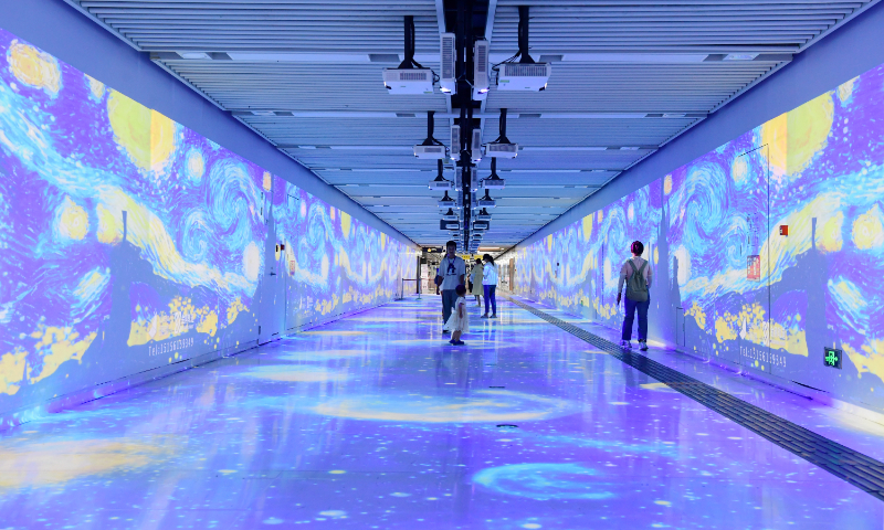 Passengers stop to enjoy the holographic projection of a Van Gogh-style starry night image at the Sanli'an metro station in Hefei, East China's Anhui Province, on August 28, 2024. Many Chinese cities are converting their subway stations into art museums, using futuristic technologies to create impressive images. Photo: VCG