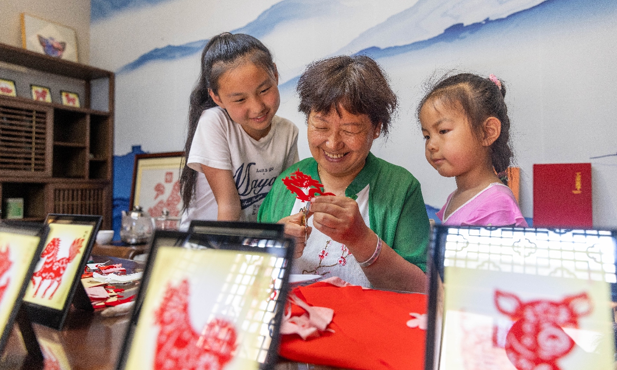 Zhao Yuxian makes paper-cuttings. Photo: Courtesy of Zhang Wujun