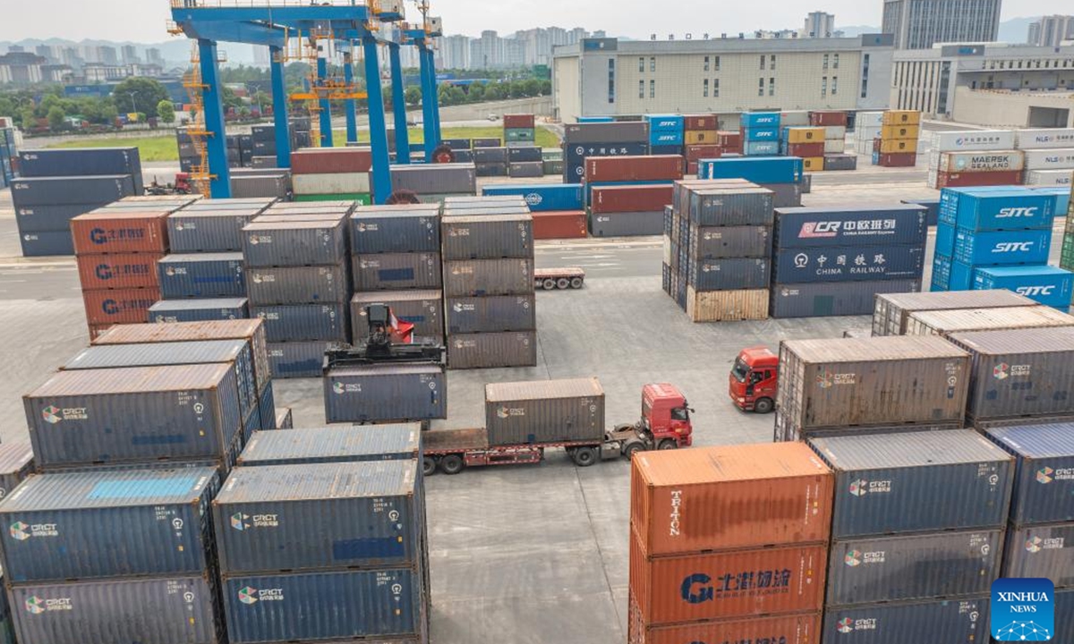 An aerial drone photo taken on July 30, 2024 shows a vehicle transferring containers at the dry port of the New International Land-Sea Trade Corridor in Chongqing International Logistics Hub Park in Shapingba District of Chongqing, southwest China. Chongqing International Logistics Hub Park, along with its 62 freight train routes, has risen to be a major hub of international freight trains in the country's western region. (Photo: Xinhua)