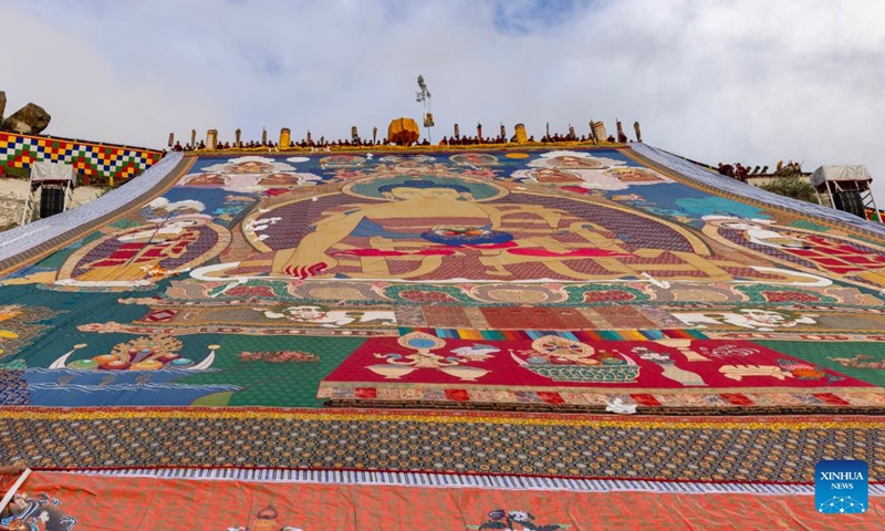 An enormous thangka painting of Buddha is unrolled on a platform on the hillside for sunning in Lhasa, southwest China's Xizang Autonomous Region, Aug. 4, 2024. Celebrations marking the traditional Shoton Festival, or Yogurt Festival, began in Lhasa, capital of southwest China's Xizang Autonomous Region, on Sunday. Photo: Xinhua