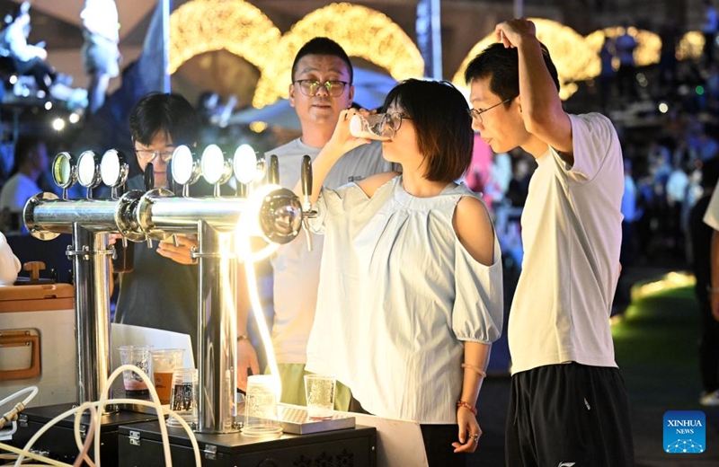 Tourists taste craft beer during the 5th Tianjin Nighttime Life Festival in north China's Tianjin Municipality, Aug. 2, 2024. The 5th Tianjin Nighttime Life Festival began here on Friday night and will last about one month. People can enjoy night markets, music shows, sports games and art exhibitions during the festival. Photo: Xinhua