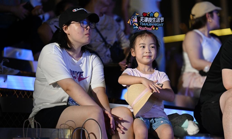 Visitors watch shows at the opening ceremony of the 5th Tianjin Nighttime Life Festival in north China's Tianjin Municipality, Aug. 2, 2024. The 5th Tianjin Nighttime Life Festival began here on Friday night and will last about one month. People can enjoy night markets, music shows, sports games and art exhibitions during the festival. Photo: Xinhua