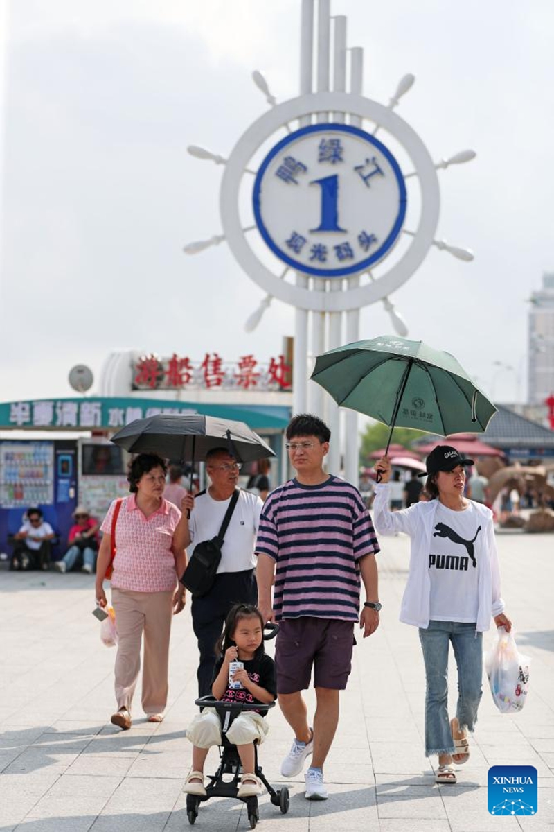 Tourists are pictured by the Yalu River in Dandong City, northeast China's Liaoning Province, Aug. 2, 2024. Tourism service has resumed as the water level in the Yalu River recedes and the riverside roads are reopened to traffic. Photo: Xinhua