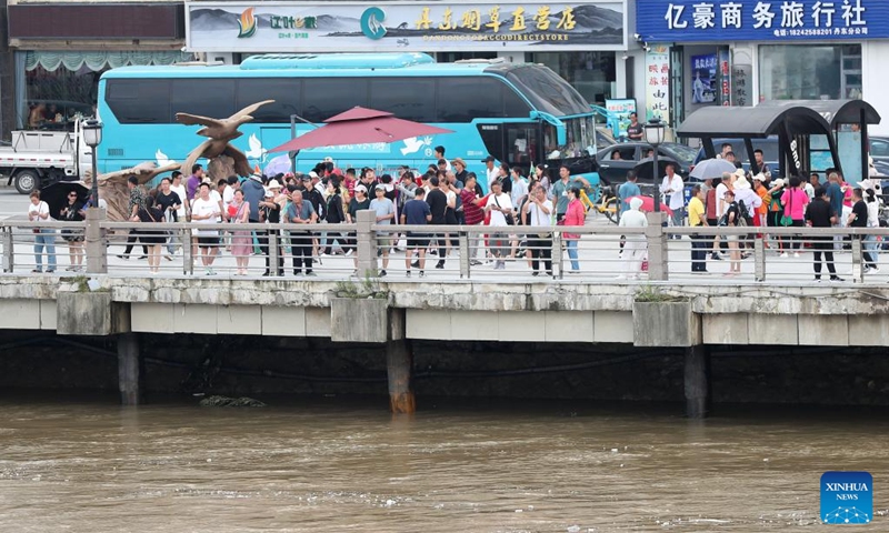 Tourists are pictured by the Yalu River in Dandong City, northeast China's Liaoning Province, Aug. 2, 2024. Tourism service has resumed as the water level in the Yalu River recedes and the riverside roads are reopened to traffic. Photo: Xinhua