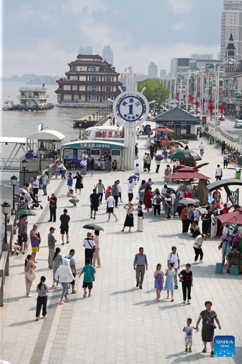 Tourists are pictured by the Yalu River in Dandong City, northeast China's Liaoning Province, Aug. 2, 2024. Tourism service has resumed as the water level in the Yalu River recedes and the riverside roads are reopened to traffic. Photo: Xinhua