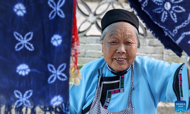 A villager is pictured in Tianlong Tunpu ancient town in Pingba District of Anshun City, southwest China's Guizhou Province, July 25, 2024. In Anshun City, southwest China's Guizhou Province, ancient stone buildings and unique local traditions have made a cluster of villages popular tourist destinations for many visitors. The stone-structured Tunpu residential buildings were built in the Ming Dynasty (1368-1644), when some troops were sent to Anshun, where they built villages and turned the neighborhood into farmland for growing crops. Their descendants have lived there over generations, and formed the unique Tunpu culture which preserved distinctive customs, architectures, operas and costumes of ancient times.  Photo: Xinhua