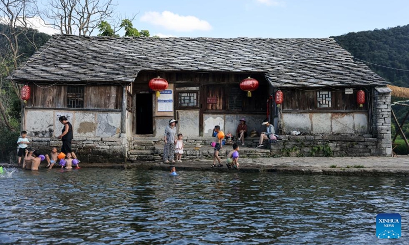 This photo taken on July 24, 2024 shows a view of Baojiatun Village in Xixiu District of Anshun City, southwest China's Guizhou Province. In Anshun City, southwest China's Guizhou Province, ancient stone buildings and unique local traditions have made a cluster of villages popular tourist destinations for many visitors. The stone-structured Tunpu residential buildings were built in the Ming Dynasty (1368-1644), when some troops were sent to Anshun, where they built villages and turned the neighborhood into farmland for growing crops. Their descendants have lived there over generations, and formed the unique Tunpu culture which preserved distinctive customs, architectures, operas and costumes of ancient times. Photo: Xinhua