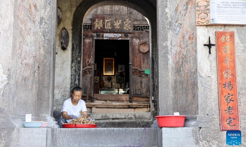 A villager sorts out beans in Benzhai Village, Xixiu District, Anshun City, southwest China's Guizhou Province, July 23, 2024. In Anshun City, southwest China's Guizhou Province, ancient stone buildings and unique local traditions have made a cluster of villages popular tourist destinations for many visitors. The stone-structured Tunpu residential buildings were built in the Ming Dynasty (1368-1644), when some troops were sent to Anshun, where they built villages and turned the neighborhood into farmland for growing crops. Their descendants have lived there over generations, and formed the unique Tunpu culture which preserved distinctive customs, architectures, operas and costumes of ancient times. Photo: Xinhua