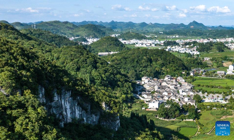 An aerial drone photo taken on July 23, 2024 shows a view of Benzhai Village in Xixiu District of Anshun City, southwest China's Guizhou Province. In Anshun City, southwest China's Guizhou Province, ancient stone buildings and unique local traditions have made a cluster of villages popular tourist destinations for many visitors. The stone-structured Tunpu residential buildings were built in the Ming Dynasty (1368-1644), when some troops were sent to Anshun, where they built villages and turned the neighborhood into farmland for growing crops. Their descendants have lived there over generations, and formed the unique Tunpu culture which preserved distinctive customs, architectures, operas and costumes of ancient times. Photo: Xinhua