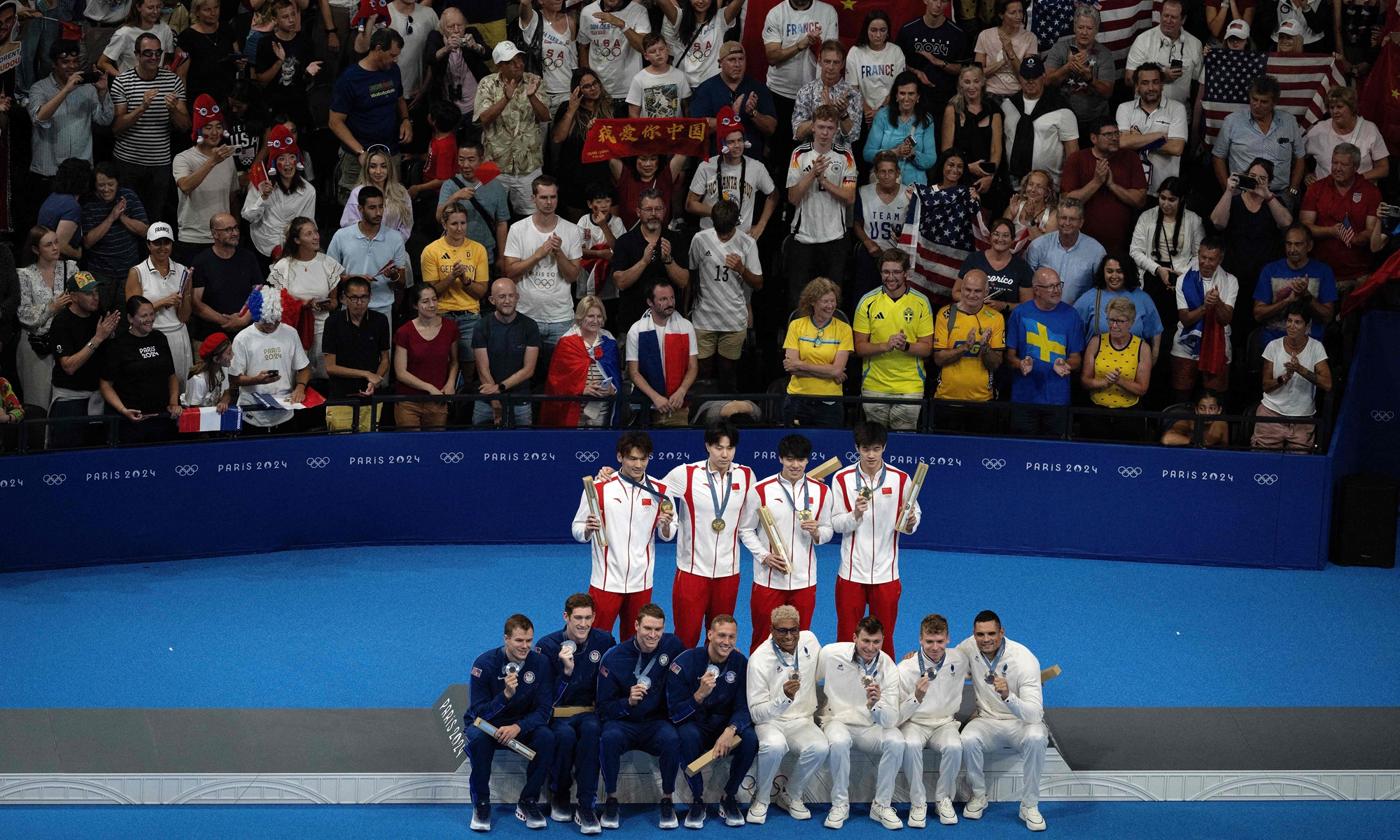 Gold medallists Team China (center), silver medallists Team USA (left), and bronze medallists Team France pose on the podium of the men's 4x100m medley relay final swimming event during the Paris 2024 Olympic Games on August 4, 2024. Photos: VCG