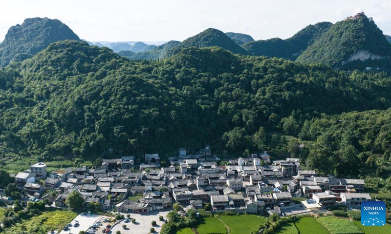 An aerial drone photo taken on July 23, 2024 shows a view of Benzhai Village in Xixiu District of Anshun City, southwest China's Guizhou Province. In Anshun City, southwest China's Guizhou Province, ancient stone buildings and unique local traditions have made a cluster of villages popular tourist destinations for many visitors. The stone-structured Tunpu residential buildings were built in the Ming Dynasty (1368-1644), when some troops were sent to Anshun, where they built villages and turned the neighborhood into farmland for growing crops. Their descendants have lived there over generations, and formed the unique Tunpu culture which preserved distinctive customs, architectures, operas and costumes of ancient times.  Photo: Xinhua