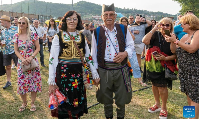 A couple in Serbian traditional folk costumes are pictured at the venue of a brass orchestra competition during the 63rd Guca Trumpet Festival in the village of Guca, Serbia on Aug. 4, 2024. (Photo: Xinhua)