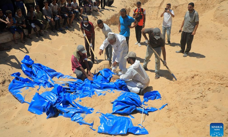 Workers bury bodies of unidentified Palestinians killed by the Israeli army in the southern Gaza Strip city of Khan Younis, on Aug. 5, 2024. Israel had returned the bodies of 89 Palestinians killed by the Israeli army in the Gaza Strip, the Hamas-run Gaza government media office said on Monday. (Photo: Xinhua)