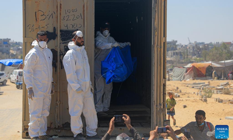 A worker removes bodies of unidentified Palestinians killed by the Israeli army in the southern Gaza Strip city of Khan Younis, on Aug. 5, 2024. Israel had returned the bodies of 89 Palestinians killed by the Israeli army in the Gaza Strip, the Hamas-run Gaza government media office said on Monday. (Photo: Xinhua)