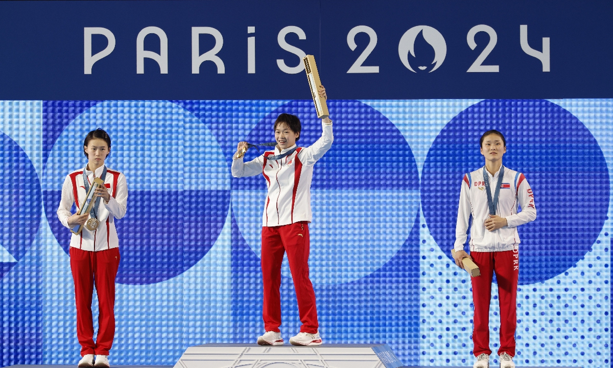 Gold medalist Quan Hongchen (center), silver medalist Chen Yuxi (left), both from China, and bronze medalist Kim Mi-rae of North Korea celebrate on the podium after the women's 10m platform diving final at the Paris Olympic Games on August 6, 2024. Quan claimed the Chinese diving team's fifth gold in Paris. Photo: Li Hao/GT