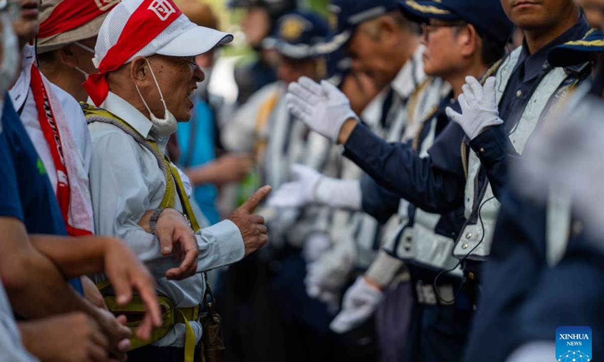 Protesters confront security personnel at Hiroshima Peace Memorial Park in Hiroshima, Japan, Aug. 6, 2024. As Japan marked the anniversary of atomic bombing on the western city of Hiroshima on Tuesday, people from across the nation gathered to protest the government's accelerated arms build-up, urging it to stick to peace.  (Photo: Xinhua)