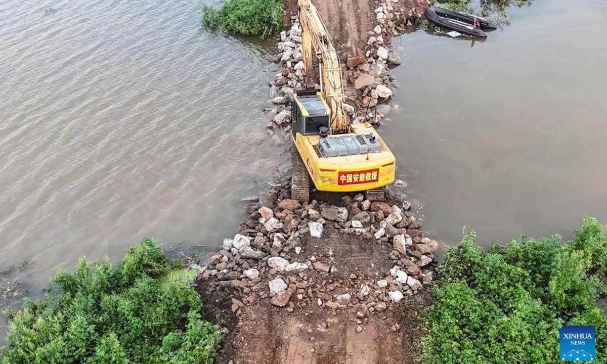 This aerial drone photo taken on Aug. 7, 2024 shows emergency workers attempting to seal a dike breach in Tieling, northeast China's Liaoning Province. The dike breach at a river in northeast China's Liaoning Province was sealed at 4:27 a.m. Wednesday after emergency workers had worked around the clock to repair it, according to local authorities.  (Photo: Xinhua)