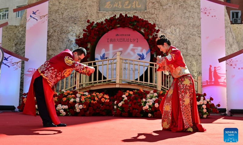 A newlywed couple attends a group wedding at the Xinjiang International Grand Bazaar in Urumqi, northwest China's Xinjiang Uygur Autonomous Region, Aug. 10, 2024. The group wedding was held here on Saturday to mark the Qixi Festival, also known as Chinese Valentine's Day. Photo: Xinhua