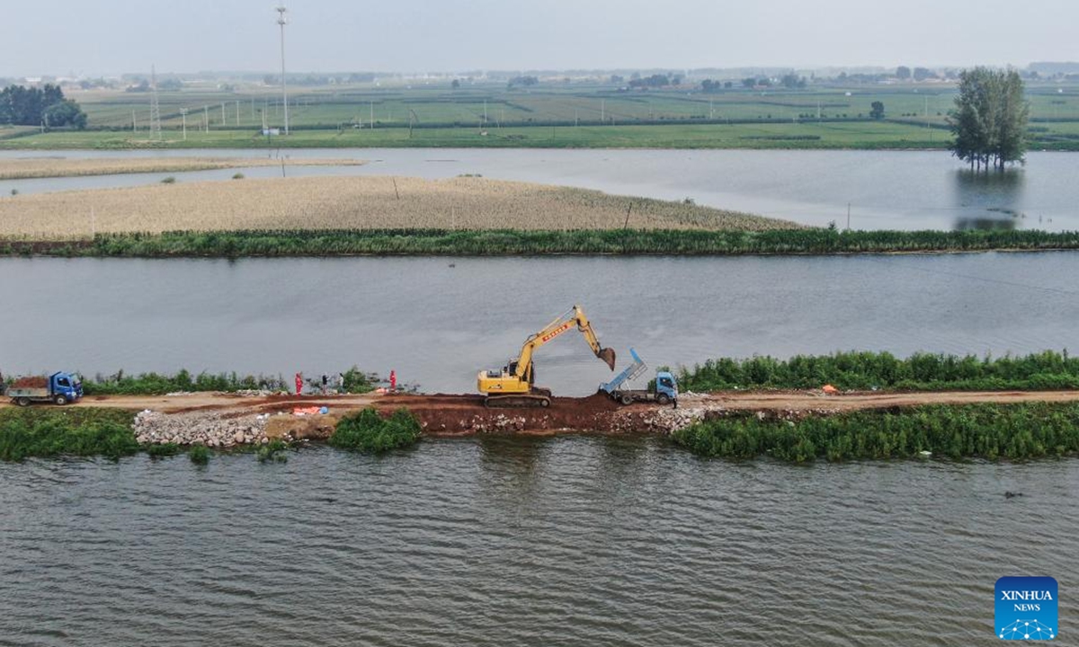 This aerial drone photo taken on Aug. 7, 2024 shows emergency workers reinforcing a newly repaired dike in Tieling, northeast China's Liaoning Province. The dike breach at a river in northeast China's Liaoning Province was sealed at 4:27 a.m. Wednesday after emergency workers had worked around the clock to repair it, according to local authorities.  (Photo: Xinhua)