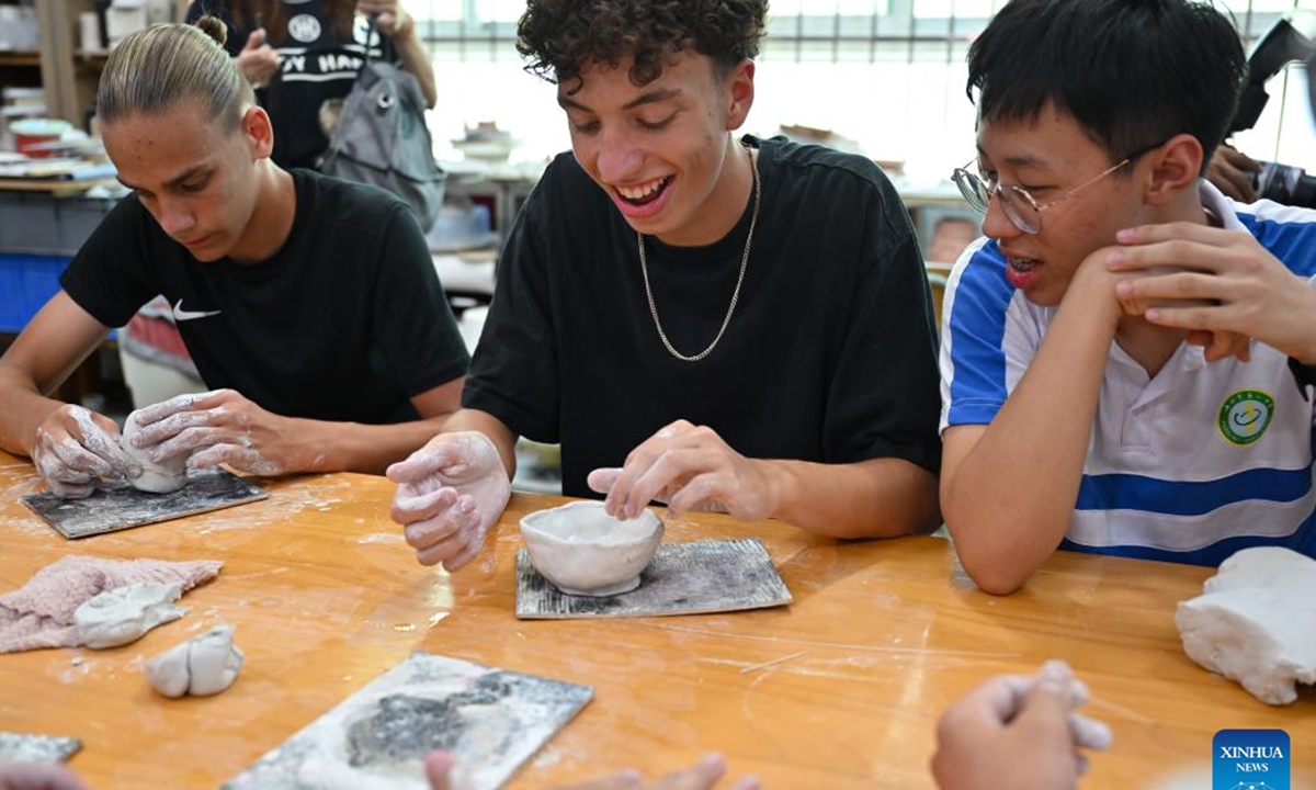 German and Chinese students try making pottery at a school in Haikou, south China's Hainan Province, Aug. 7, 2024. German students attending a Sino-German U16 football tournament visited a middle school in Haikou for a study tour on Wednesday. (Photo: Xinhua)