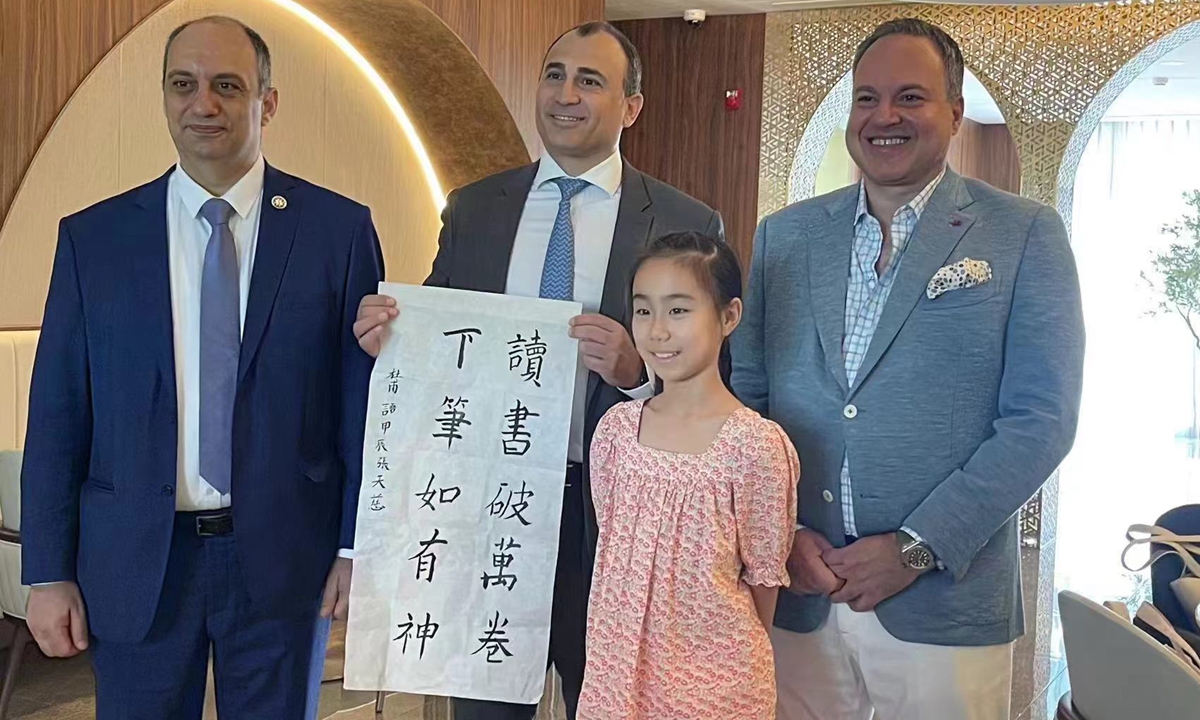 Mansour Chaya, deputy chief of mission at the Embassy of Lebanon in China, (second from the left) poses for a photo with a Chinese girl during the food fest in Beijing, on August 5, 2024. Photo: Courtesy of the Embassy of Lebanon in China