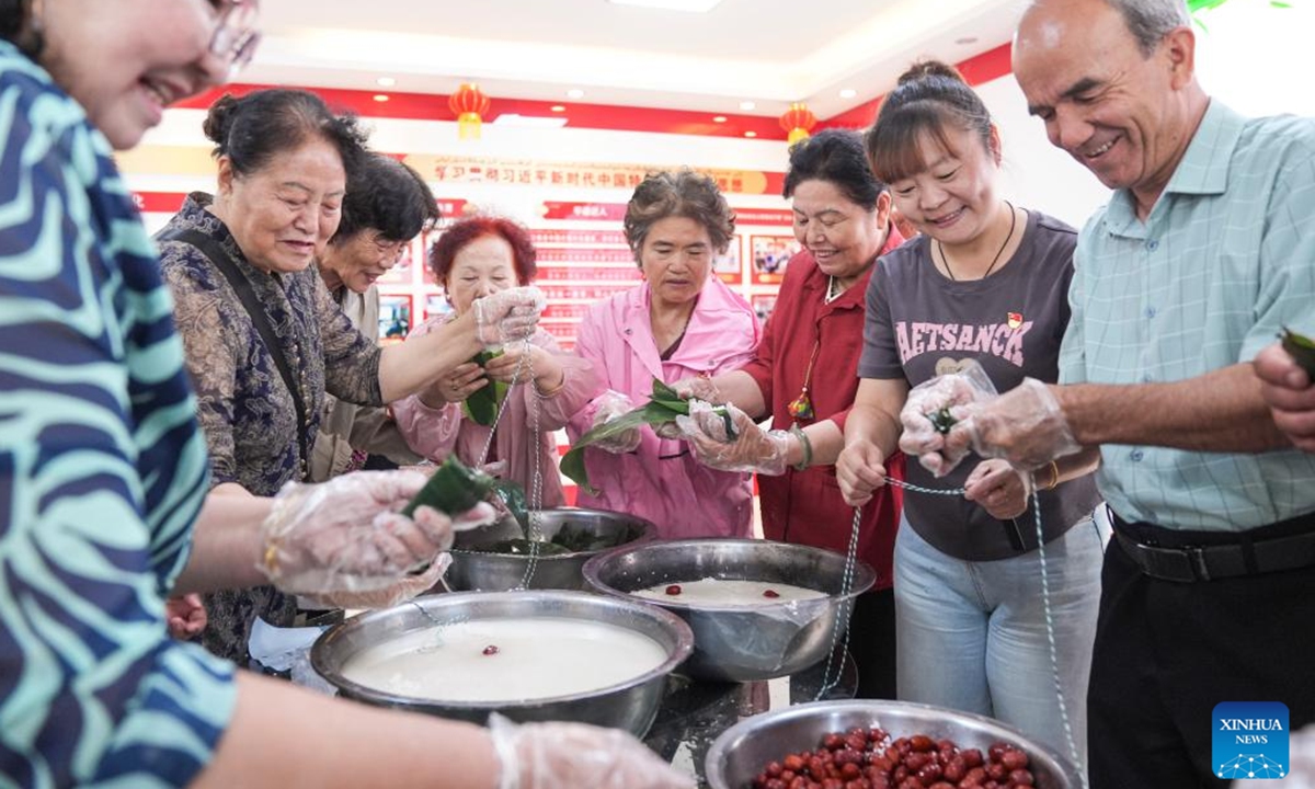 Residents make zongzi (sticky rice dumplings), a traditional Chinese delicacy typically consumed during the Dragon Boat Festival, at Guyuanxiang Community in Urumqi, northwest China's Xinjiang Uygur Autonomous Region, June 6, 2024. (Photo: Xinhua)