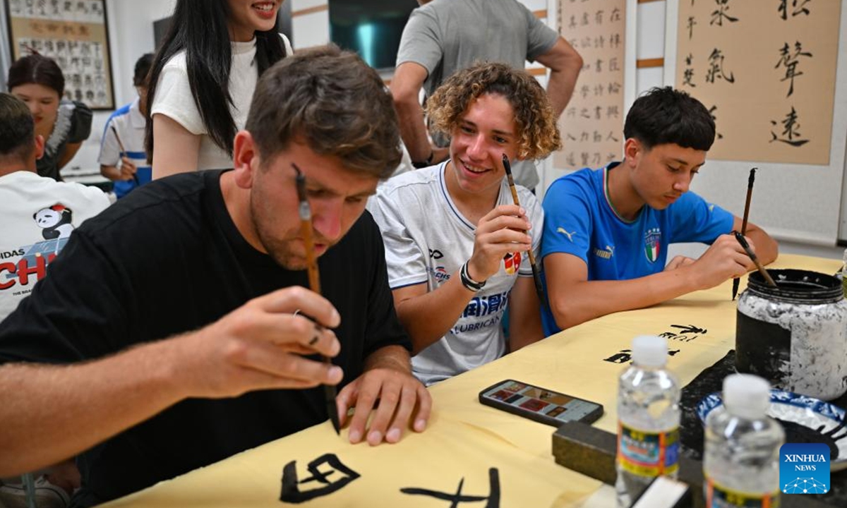 German students and teachers learn Chinese calligraphy at a school in Haikou, south China's Hainan Province, Aug. 7, 2024. German students attending a Sino-German U16 football tournament visited a middle school in Haikou for a study tour on Wednesday. (Photo: Xinhua)