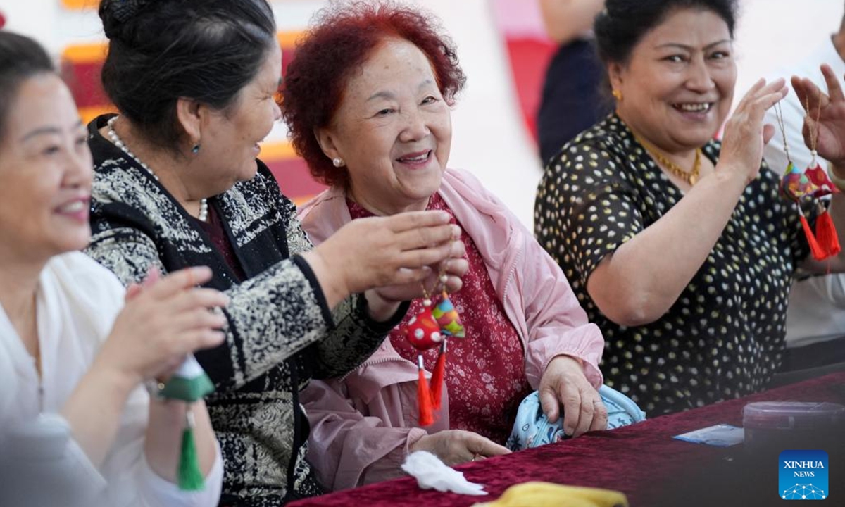 Residents make sachets during a celebration of the Dragon Boat Festival at Guyuanxiang Community in Urumqi, northwest China's Xinjiang Uygur Autonomous Region, June 6, 2024. (Photo: Xinhua)