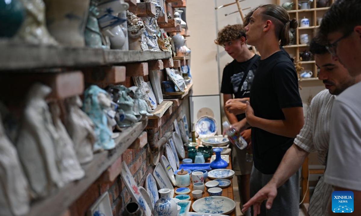 German students view pottery works at a school in Haikou, south China's Hainan Province, Aug. 7, 2024. German students attending a Sino-German U16 football tournament visited a middle school in Haikou for a study tour on Wednesday. (Photo: Xinhua)